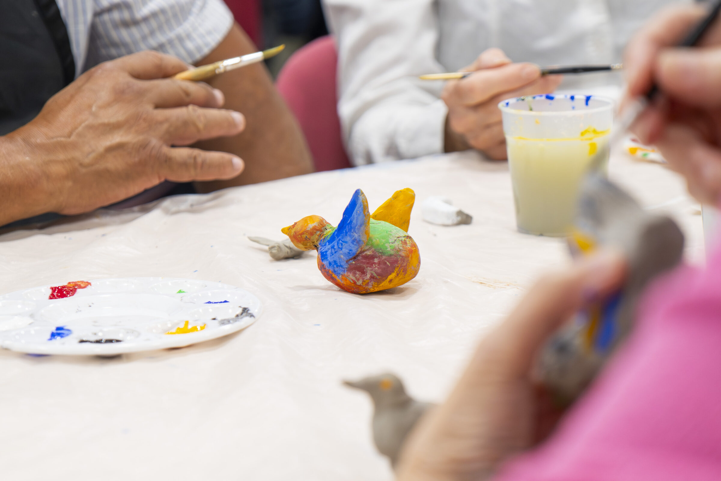 Participants painting ceramic bird bright colours