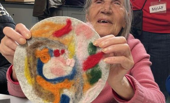Participant holding their bright coloured felting design