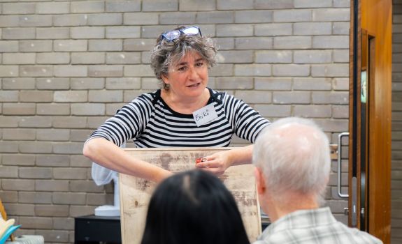 Artist demonstrating using paper to create mosaic piece