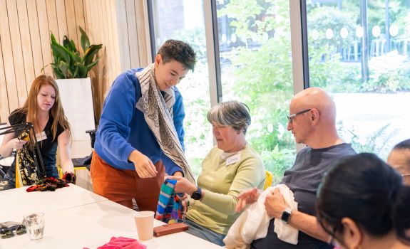 Artist and participants discussing colour and texture of scarves