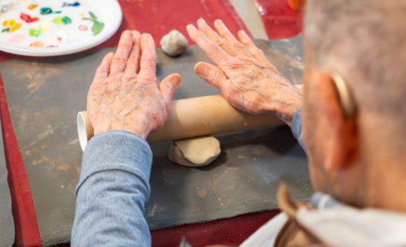 Participant rolling clay during a workshop
