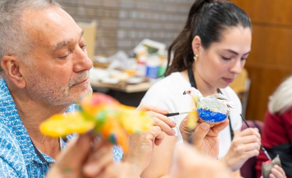 Frank painting a ceramic bird he created during the workshop