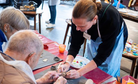 Helen helping a participant work with clay during a workshop