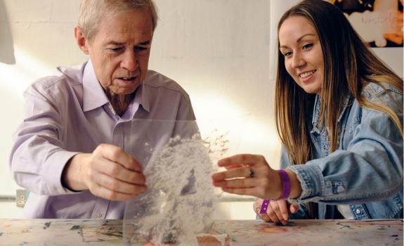 Arts for dementia facilitator and participant holding an art on glass piece together