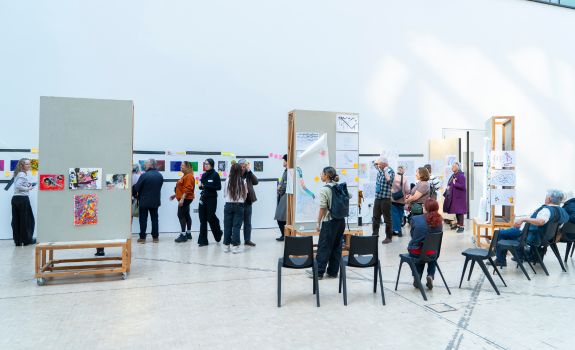 Distance photo of many people browsing the CSM exhibition