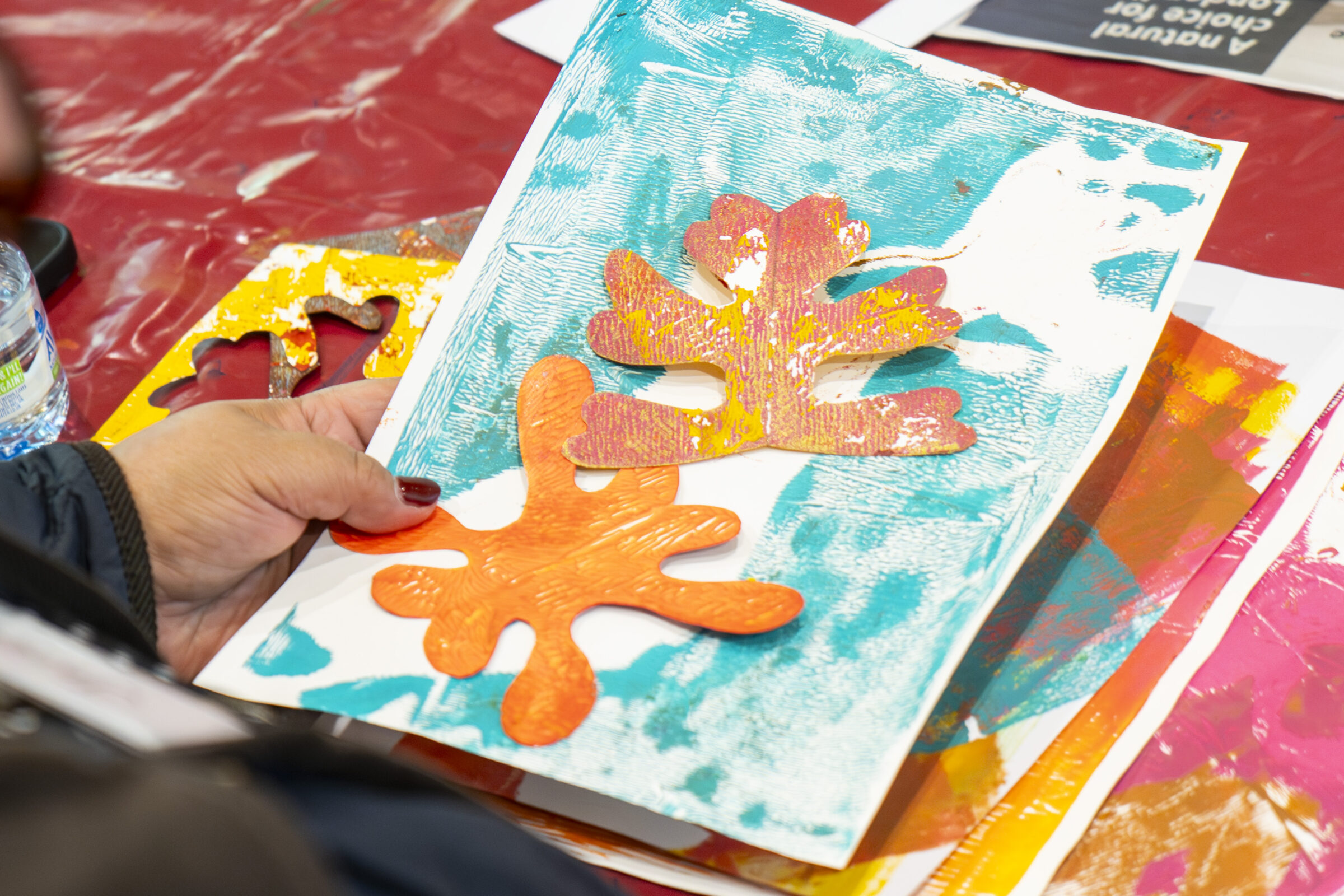 Printed paper with cut out paper shapes held in a hand