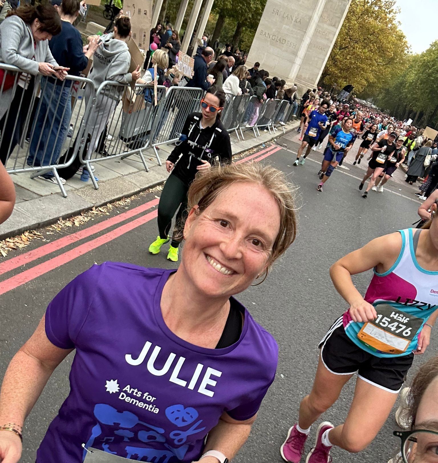 Julie smiling and happy on the course of the Royal Parks Half Marathon