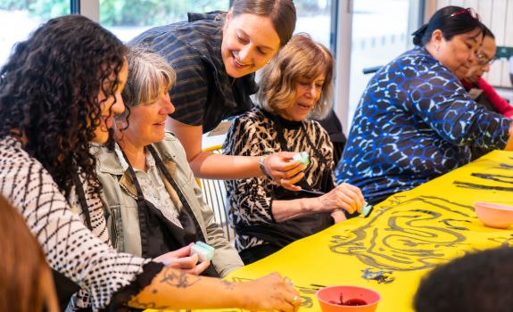 Participants and artist creating print collaborative piece