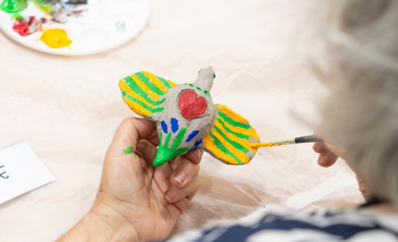 Participant painting a hand made ceramic bird