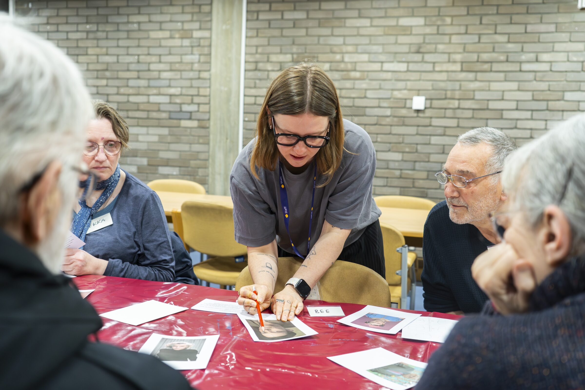 Lady showing artwork to a group of people at a class.